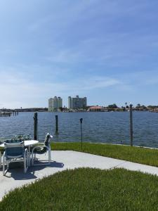 einen Tisch und Stühle neben einem Wasserkörper in der Unterkunft Beautiful St Pete Beach, FL 2nd Floor 2BR Unit in St Pete Beach