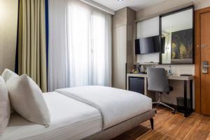 a bedroom with a bed and a desk with a computer at Dem Premium Hotel - Round Trip Airport Service - Istanbul International Airport in Arnavutköy