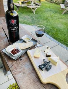 uma garrafa de vinho, um prato de queijo e um copo em The Greyhound Inn em Dorchester