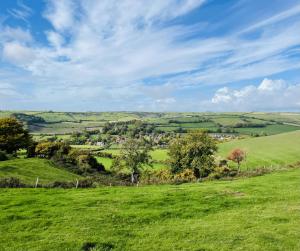 a green field with trees and a town in the distance at The Greyhound Inn in Dorchester