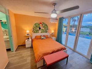 a bedroom with a bed and a large window at Casa De Sol Family Home Near Rincon & Beach in Aguada