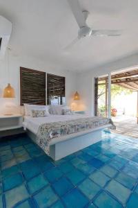 1 dormitorio con 1 cama grande y suelo de baldosa azul en Wonderful House Paradise in the Rosario Islands, en Cartagena de Indias