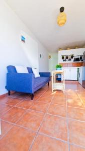 a living room with a blue couch and a table at El poniente in Caleta de Sebo