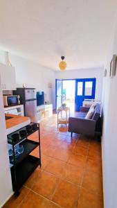 ein Wohnzimmer mit einem Sofa und einer Küche in der Unterkunft El poniente in Caleta de Sebo