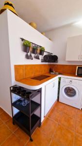 a kitchen with a sink and a washing machine at El poniente in Caleta de Sebo