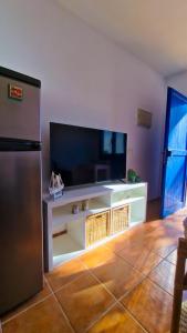 uma sala de estar com uma televisão e um frigorífico em El poniente em Caleta de Sebo
