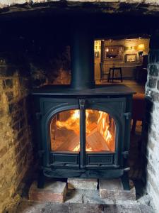 a stove with a fire in a brick fireplace at The Greyhound Inn in Dorchester