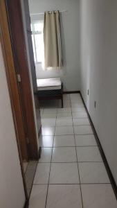 瓜拉派瑞Apartamento a poucos passos do mar的客房设有窗户和瓷砖地板。