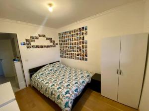 - une chambre dotée d'un lit avec des photos sur le mur dans l'établissement Nice Ouest St Isidore- 2P au calme, à Nice