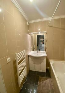 a bathroom with a sink and a tub and a mirror at Nice Ouest St Isidore- 2P au calme in Nice