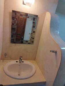 y baño con lavabo y espejo. en Hotelito Crismi en Holbox Island