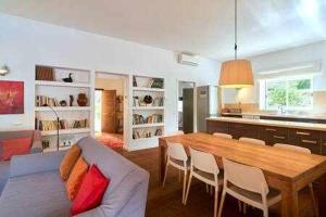 a living room with a dining table and a kitchen at Can coll des cocons barefoot house 5min from pacha in Ibiza Town