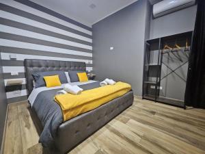 a bedroom with a bed with a yellow blanket at B&B Be happy in Taranto