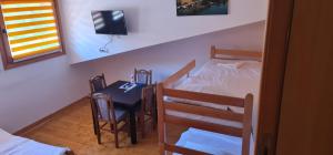 a bedroom with a table and a bed and a table and chairs at Apartmani,kucice DRINA-BOK in Ljubovija