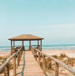 a wooden boardwalk leading to a beach with the ocean at Paraíso tropical in Balneário Gaivotas
