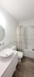 a white bathroom with a toilet and a sink at Chacras del Mar - Acceso exclusivo vehiculo 4 x 4 in Mar Azul