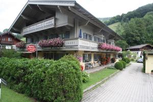 ルーポルディングにあるAm Hadermarkt inkl. Chiemgaukarteのバルコニーに花と止め印のある建物