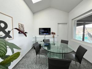 uma sala de jantar com uma mesa de vidro e cadeiras em Wohnung mit grossartiger Seesicht und Balkon em Spiez