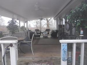 a porch with chairs and a table on a house at serenity hill in Brownsville