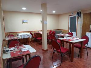 un comedor con mesas y sillas y copas de vino. en Hostal Reymar, en Puerto Natales