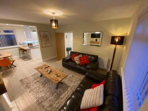 拉格斯的住宿－Wellbank View - Brand New，客厅配有真皮沙发和茶几