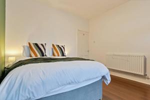 - une chambre blanche avec un grand lit et des oreillers rayés dans l'établissement Becky's House: Near Motor Point Arena with Free Parking, à Nottingham