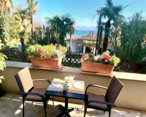 a table and chairs on a balcony with plants at Apartments Dujmic - 50m from the sea with private parking in Ičići