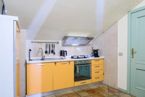kuchnia z żółtymi szafkami i zlewem w obiekcie Appartamento compagnoni w mieście Macerata