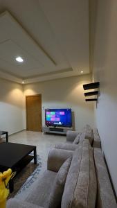 a living room with a couch and a flat screen tv at شقة مفروشة وسط الرياض in Riyadh