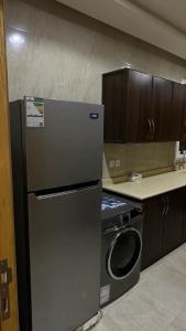 a kitchen with a refrigerator and a washing machine at شقة مفروشة وسط الرياض in Riyadh