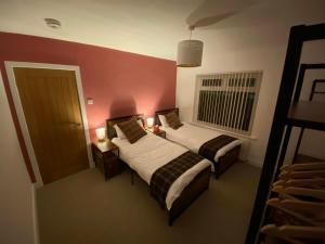 two beds in a room with red walls at Wellbank View - Brand New in Washington