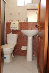 y baño con aseo y lavamanos. en Hotel Palma Real Cartagena, en Cartagena de Indias