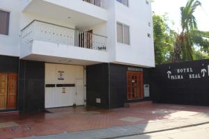a white and black building with a balcony at Hotel Palma Real Cartagena in Cartagena de Indias