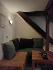 - un salon avec un canapé vert et une table dans l'établissement Le Vieux La Roche, à La-Roche-en-Ardenne