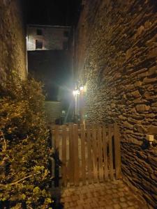 a wooden bench sitting next to a stone wall at night at Le Vieux La Roche in La Roche-en-Ardenne