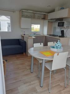 a kitchen and dining room with a table and chairs at Stacaravan Bredene met tuin nr 2126 in Bredene