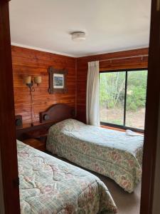 - 2 lits dans une chambre avec fenêtre dans l'établissement Cabaña Pingüeral (Derecho a piscina verano), à Dichato