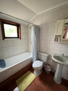 La salle de bains est pourvue d'une baignoire, de toilettes et d'un lavabo. dans l'établissement Cabaña Pingüeral (Derecho a piscina verano), à Dichato