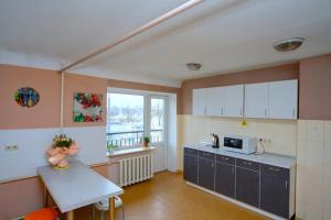 a kitchen with a counter and a table and a window at Hostel Podolski Plus in Kyiv