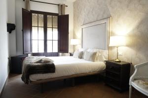 Un dormitorio con una cama grande y una ventana en Hospedarte Cazadero Real en El Rocío