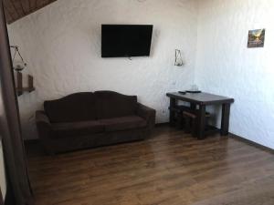 ein Wohnzimmer mit einem Sofa und einem Tisch in der Unterkunft Complex Khutor in Velyka Omelyana
