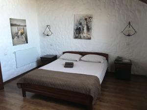 - une chambre avec un lit et deux photos sur le mur dans l'établissement Complex Khutor, à Velyka Omelyana