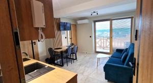 a living room with a blue couch and a table with chairs at Apartament Oliwia in Kluszkowce