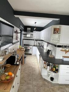 a large kitchen with white cabinets and a counter at La Maison des Rêves - Bran in Bran