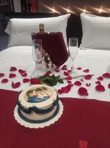 - une table avec un gâteau, deux verres et des roses dans l'établissement KHotel, à León