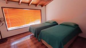 2 camas individuales en una habitación con ventana en Sítio Encontro das Águas Brotas, en Ibirapuera