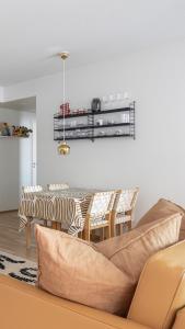 een woonkamer met een bank en een tafel en stoelen bij Top, cozy, lakeside, sauna and free indoor parking in Tampere