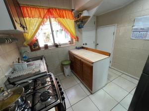 a small kitchen with a stove and a window at Hostal Rosario in La Serena