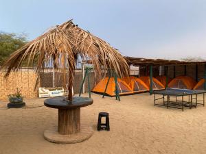 a group of tents in the sand with a table at Pepon Surf Camp in Máncora