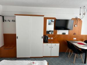 a room with a white cabinet and a table with a tv at Mitterdorf Almberg x29 in Mitterfirmiansreut